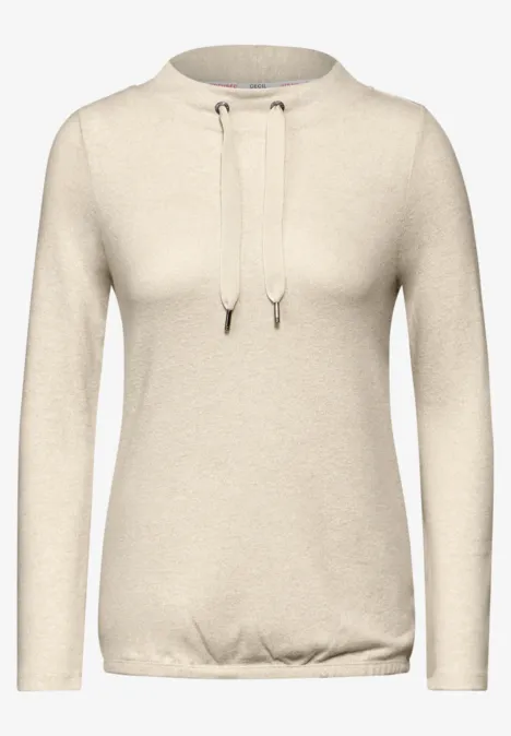 Beiger Pullover mit langen Ärmeln und Kordelzug am Kragen.